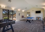 Thumbnail 16 of 23 - Game room with a pool table foosball and ping pong at Mountain Run Apartments, Albuquerque