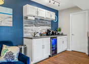 Thumbnail 33 of 64 - Clubhouse kitchen with white cabinets and a blue wall at Lofts of Wilmington, Wilmington, NC