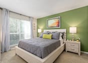 Thumbnail 14 of 43 - Bedroom with a bed and a window at University Ridge Apartments, Durham, NC, 27707