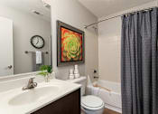 Thumbnail 17 of 43 - Bathroom with a sink toilet and tub and a shower curtain at University Ridge Apartments, Durham, NC, 27707