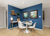 Thumbnail 10 of 43 - Dining room with blue walls and a white table and chairs at University Ridge Apartments, Durham, NC, 27707