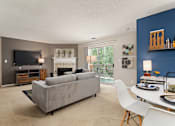 Thumbnail 9 of 43 - Living room with a couch and a table and a television at University Ridge Apartments, Durham, NC, 27707