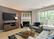Thumbnail 8 of 43 - Living room with couches and a tv and a fireplace at University Ridge Apartments, Durham, NC, 27707