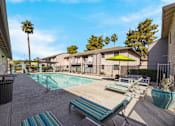 Thumbnail 16 of 22 - Swimming pool with lounge chairs and umbrellas at 2900 Lux Apartment Homes, Nevada