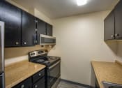 Thumbnail 16 of 33 - a kitchen with a stove top oven next to a microwave at Broadmoor Springs, Colorado Springs, CO, 80906