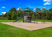 Thumbnail 6 of 33 - a sandpit with a jungle gym and slide in the middle of a grassy park at Broadmoor Springs, Colorado Springs, CO, 80906