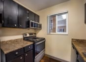 Thumbnail 25 of 33 - a kitchen with a stove top oven next to a window at Broadmoor Springs, Colorado Springs, CO, 80906