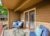 Thumbnail 7 of 16 - a covered porch with chairs and a table at The Glen Apartments, Texas