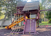 Thumbnail 34 of 41 - A playground with a slide and a wooden structure at North Creek Apartments, Everett, Washington, 98208