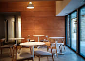 Thumbnail 38 of 45 - a dining room with tables and chairs in front of a wood wall at Spyglass Creek, Denver, 80224