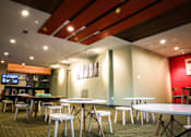 Thumbnail 39 of 45 - a dining area with tables and stools and a bar in the background at Spyglass Creek, Denver, 80224