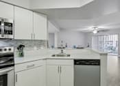 Thumbnail 5 of 50 - a kitchen with white cabinets and a sink and a stove at Pembroke Pines Landings, Florida