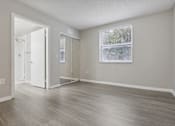 Thumbnail 20 of 50 - an empty living room with wood floors and a window at Pembroke Pines Landings, Florida