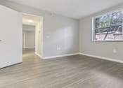 Thumbnail 23 of 50 - an empty living room with a large window and wood flooring at Pembroke Pines Landings, Pembroke Pines, FL 33025
