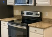 Thumbnail 20 of 31 - Kitchen with White Cabinets and Black Appliances at Arcadia Townhomes, Federal Way, WA, 98023