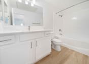 Thumbnail 13 of 65 - A white bathroom with a toilet, sink, and bathtub.