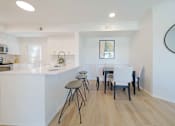 Thumbnail 4 of 65 - A kitchen with white cabinets and a white island with a bar stool.