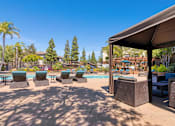 Thumbnail 56 of 65 - A poolside area with lounge chairs and a canopy.