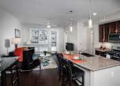 Thumbnail 14 of 27 - an open apartment space with large windows, an island and seating, and large windows