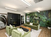 Thumbnail 12 of 22 - A living room with a green couch and a fireplace.