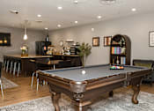 Thumbnail 13 of 22 - A pool table is in the middle of a room with a bar and a dining table.