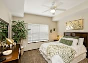 Thumbnail 2 of 22 - A bedroom with a bed, a ceiling fan, and a painting on the wall.