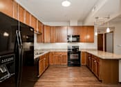Thumbnail 4 of 22 - A kitchen with wooden cabinets and black appliances.