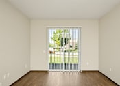 Thumbnail 8 of 22 - A room with a sliding glass door leading to a backyard.