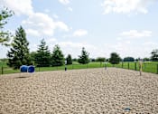 Thumbnail 17 of 22 - A playground with a blue barrel and yellow sand.