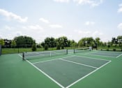 Thumbnail 15 of 22 - A tennis court with white lines and a net.
