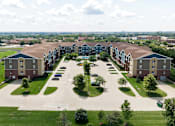 Thumbnail 22 of 22 - A large apartment complex with a parking lot in front.