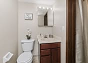 Thumbnail 20 of 24 - A white toilet sits next to a sink in a bathroom.