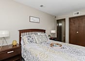 Thumbnail 16 of 24 - A bedroom with a bed, nightstand, and lamp.