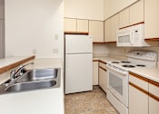 Thumbnail 13 of 37 - A kitchen with a white refrigerator, white oven, and a white microwave.