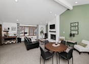 Thumbnail 17 of 24 - A living room with a fireplace and a dining table.