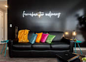 Thumbnail 8 of 27 - a black couch against a black accent wall with colorful pillows
