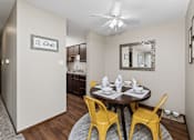 Thumbnail 14 of 24 - A dining room with a round table and yellow chairs.