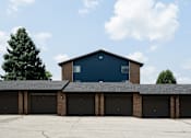 Thumbnail 18 of 24 - A blue building with a black roof and a garage door.