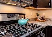 Thumbnail 7 of 27 - a teapot on the stove in a kitchen with a microwave