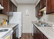 Thumbnail 15 of 24 - A kitchen with a white fridge and wooden cabinets.