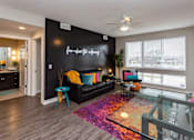 Thumbnail 6 of 27 - an open living room with large windows and a black accent wall. pops of color throughout the room