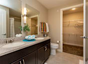 Thumbnail 10 of 27 - master bedroom with double sinks, a toliet, and a large walk-in closet