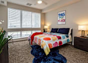 Thumbnail 12 of 27 - master bedroom with floor-to-ceiling windows, a brightly colored bed spread, and a well-lit space