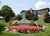 Thumbnail 2 of 24 - A sign for Country Club Village Apartments is in front of a building.
