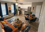 Thumbnail 1 of 17 - A living room with a brown couch and a rug.