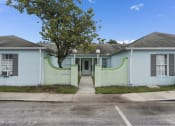Thumbnail 14 of 29 - a white and green house with a tree in front of it at The Groves at Wimauma Apartments , Wimauma, FL, 33598