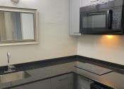 Thumbnail 4 of 18 - a kitchen with a sink and a microwave at Colonial Apartments, Orlando Florida