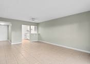Thumbnail 67 of 74 - the living room and kitchen of an empty house with a tiled floor at Cypress Grove, Lauderhill, 33313