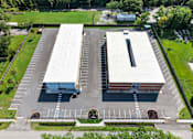Thumbnail 5 of 17 - An aerial view of a parking lot with two buildings.