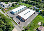 Thumbnail 13 of 17 - A large building with a parking lot in front of it.
